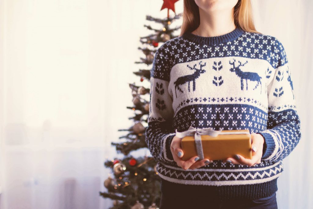 Person holding a Christmas gift, Christmas tree